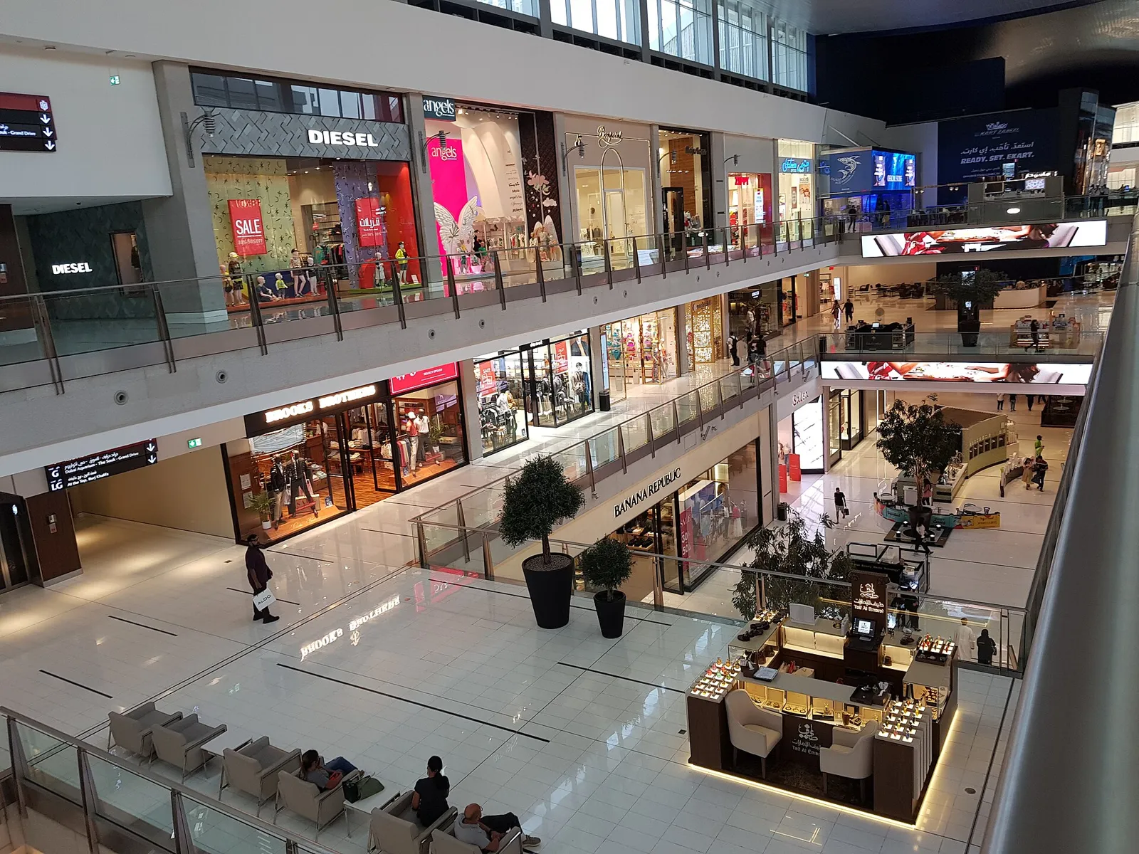 Inside Dubai Mall, with shops on several levels and trees in the central atrium