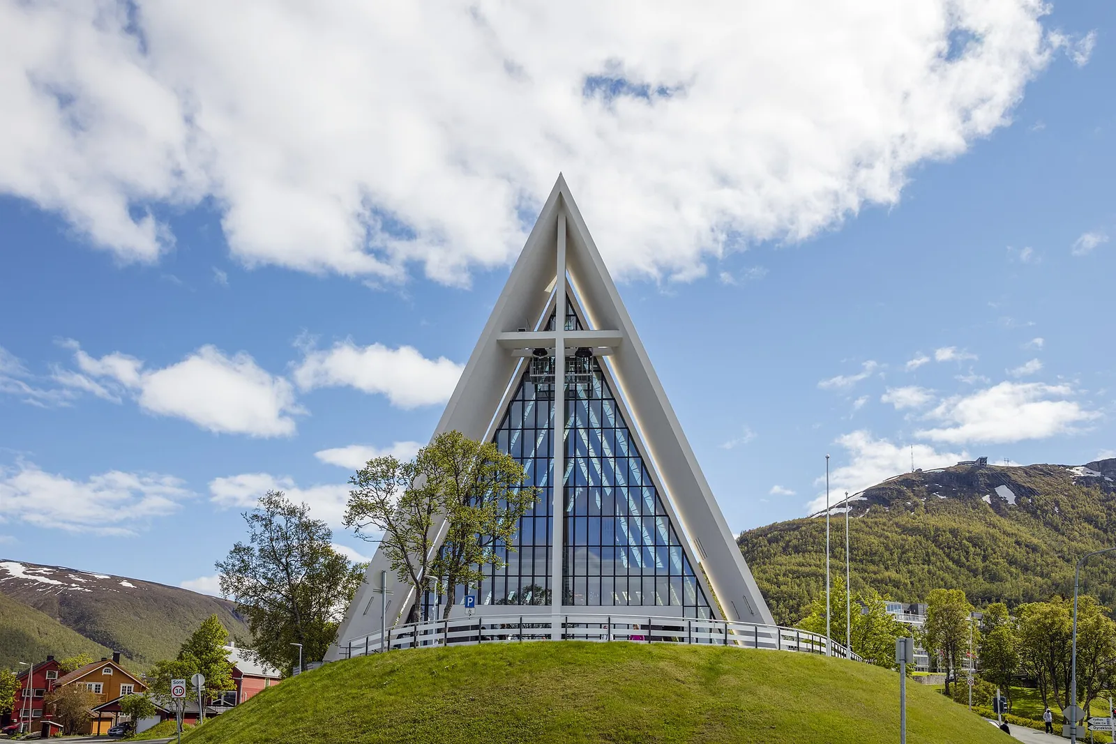 The white, triangular Arctic Cathedral in Tromsdalen, Tromsø, under a blue sky