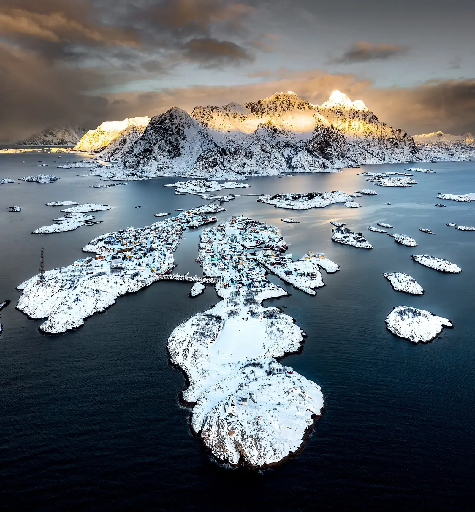 Aerial view of snow-covered Henningsvær and its harbour islands in Lofoten in winter