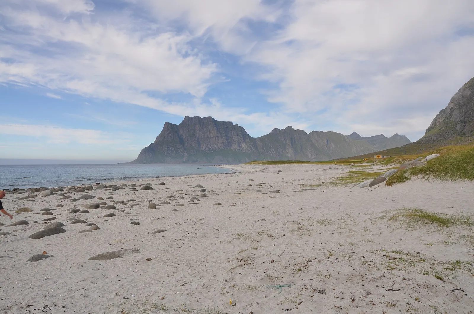 Boulder-strewn sand at Uttakleiv beach on Vestvågøy, Lofoten, below steep mountains