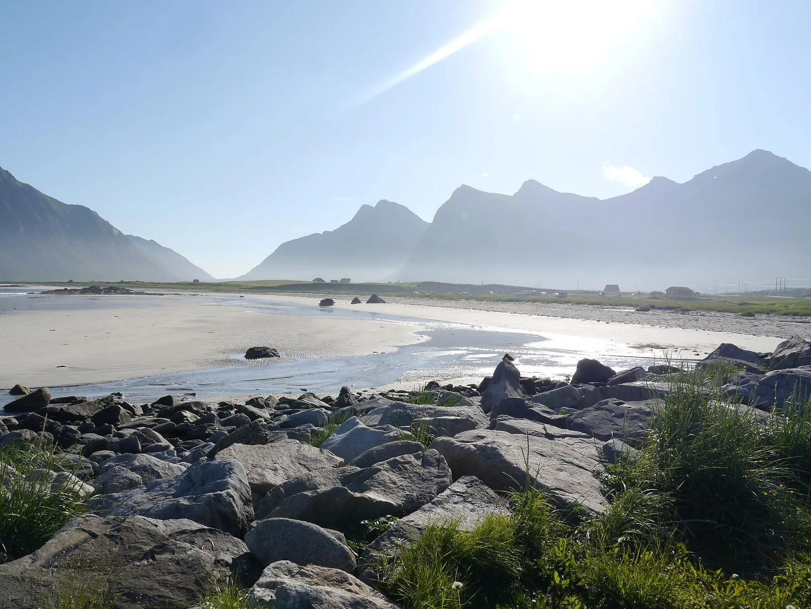 Rocky shore and sandy beach at Skagsanden, Flakstad, with Lofoten mountains behind