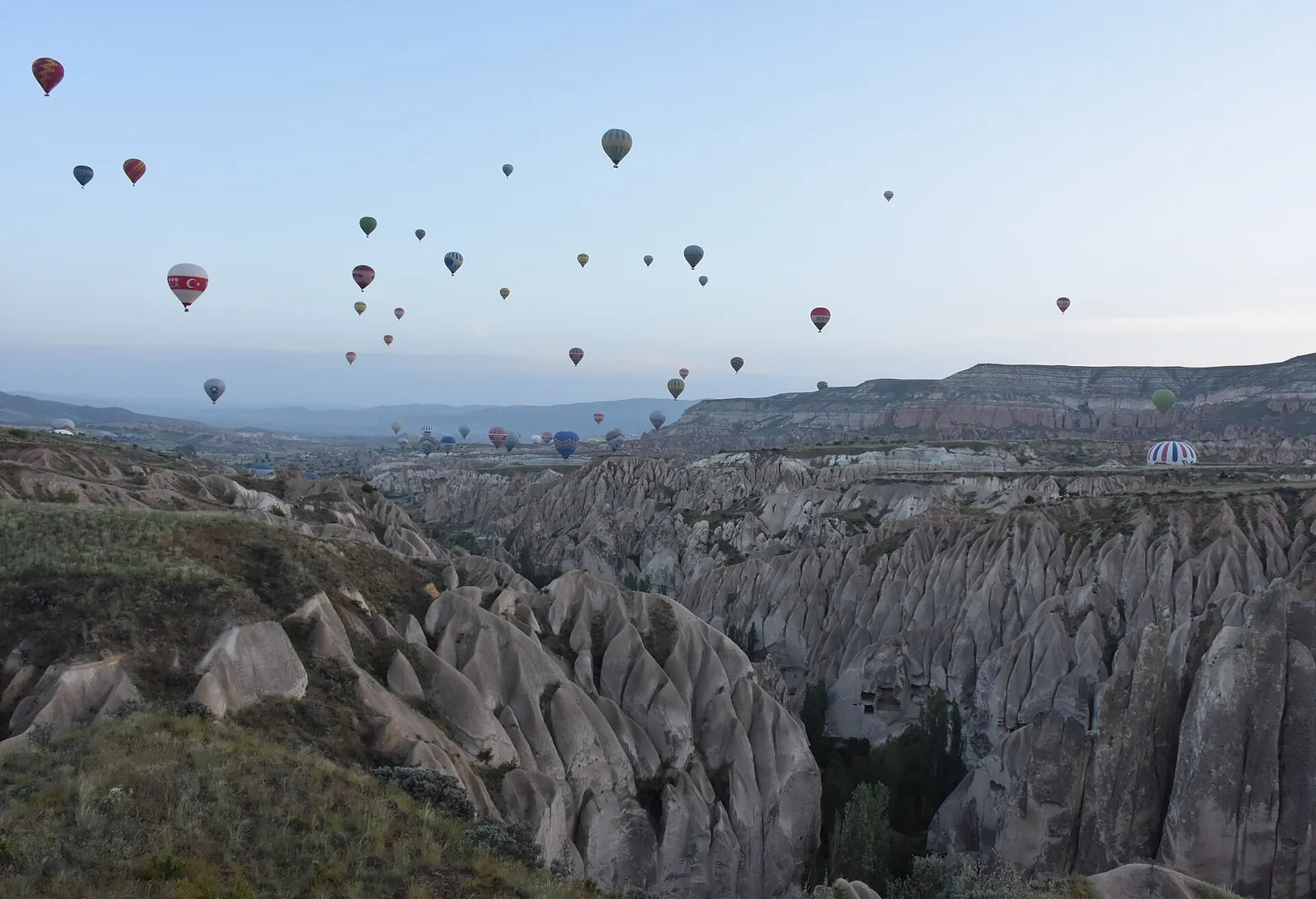 Hot air balloons over fairy chimney rock formations at sunrise near Göreme, Cappadocia
