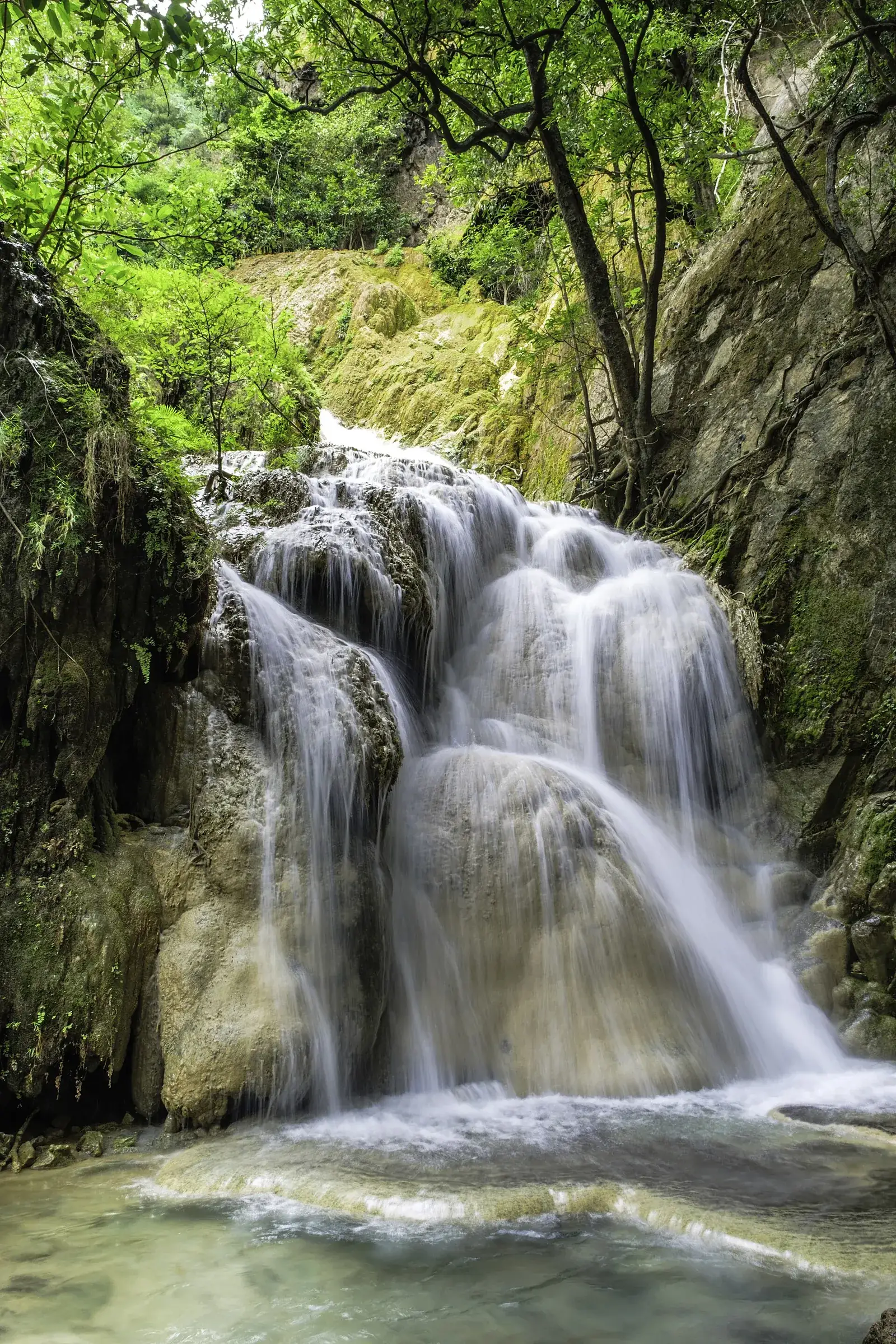 Water cascading over limestone tiers at Erawan Falls in Erawan National Park, Kanchanaburi