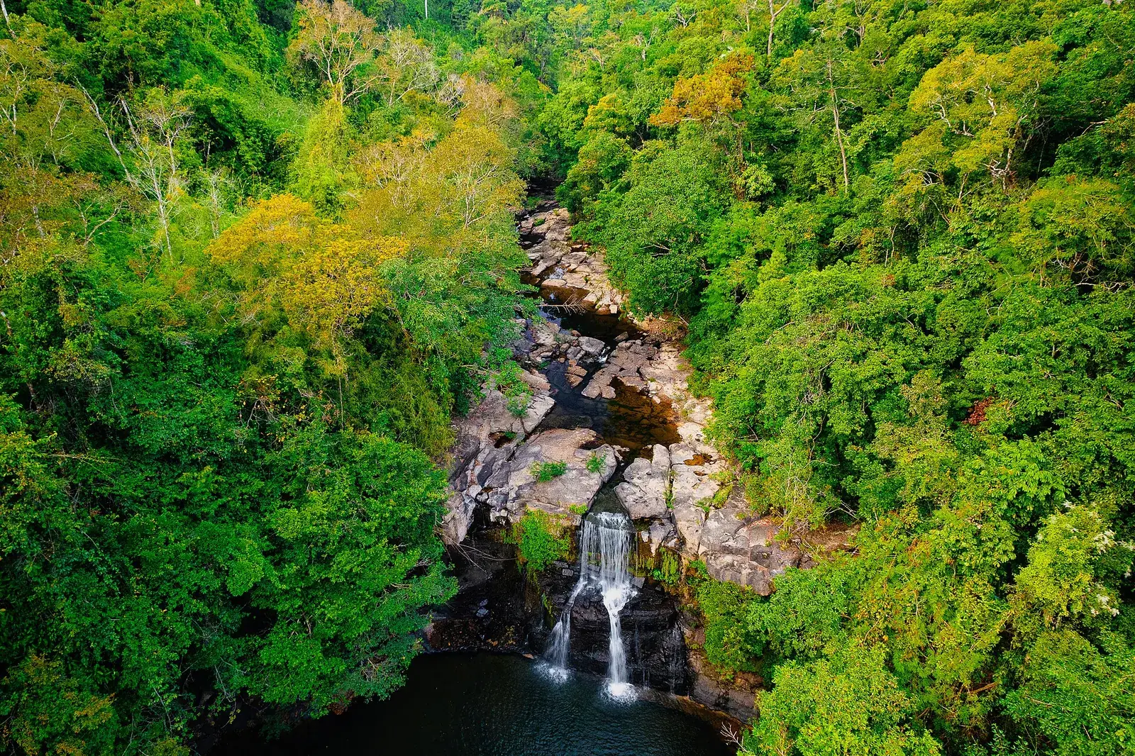 Aerial view of Khlong Chao waterfall dropping into a jungle pool on Koh Kood, Trat province