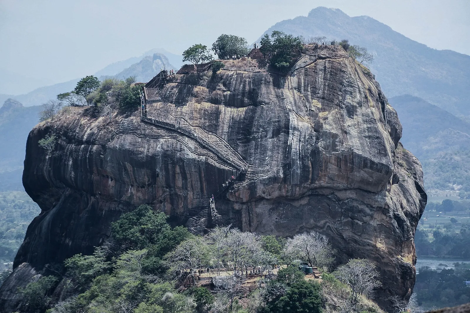 The sheer granite face of Sigiriya rock fortress rising above the trees
